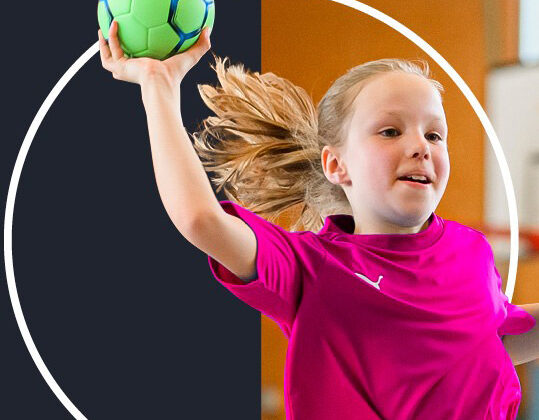 Ein junges Mädchen in einem hellrosa Sporthemd springt mit einem grünen Handball in der erhobenen rechten Hand, bereit zum Wurf, vor einem geteilten dunklen und orangefarbenen Hintergrund mit einem weißen Kreismuster.