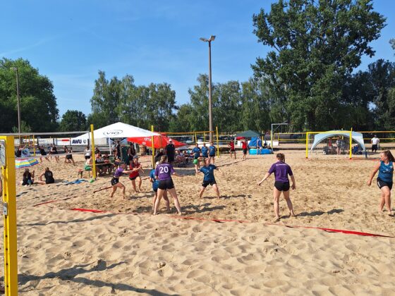 Eine Gruppe von Menschen, die an einem sonnigen Tag während des HVB-Pokal-Final-Four 2026/27 Beachvolleyball spielen.