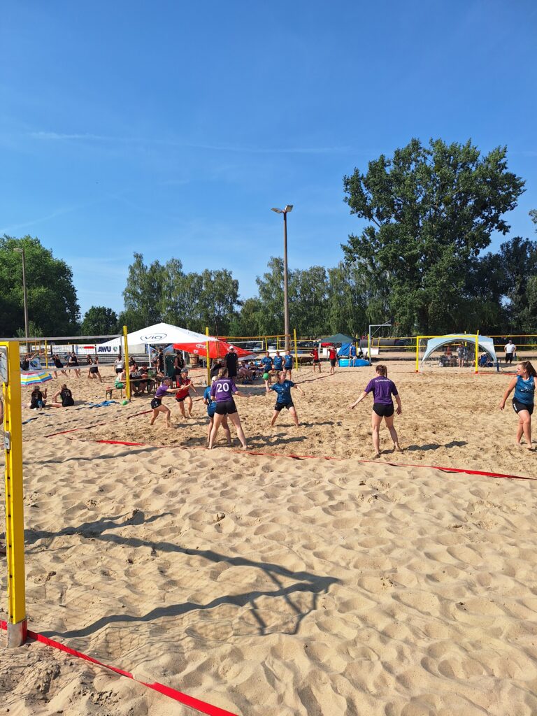Eine Gruppe von Menschen, die an einem sonnigen Tag während des HVB-Pokal-Final-Four 2026/27 Beachvolleyball spielen.